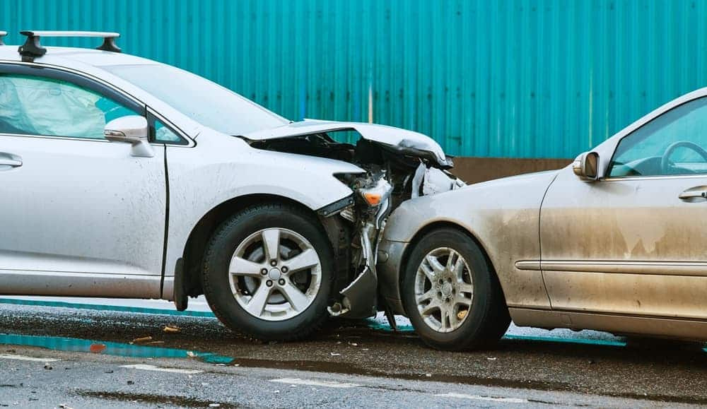 Head-on collision between two cars on the road