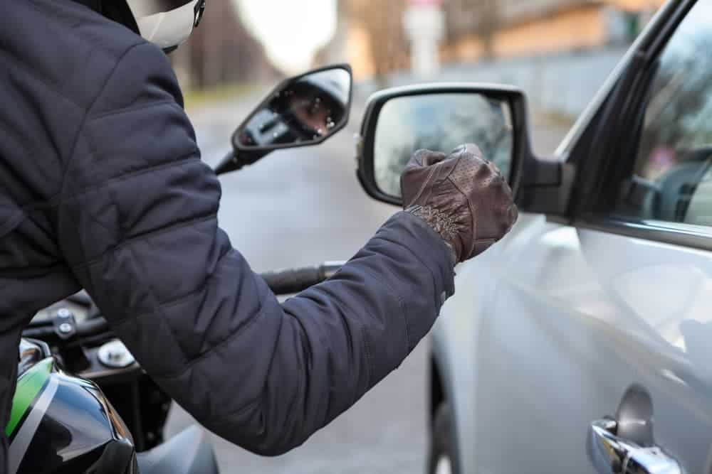 Motorcyclist knocking on the car window with a glove, close-up