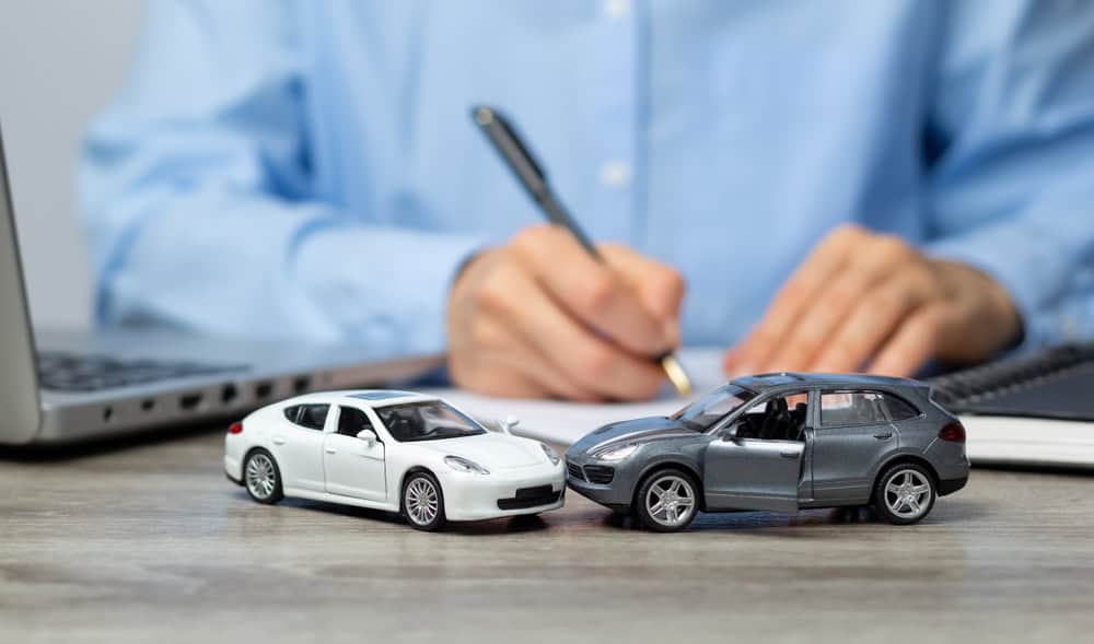 An insurance company employee prepares a paper form for a traffic accident. Legal assistance with a car accident.