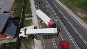 Aerial view of a serious truck accident on a highway, highlighting potential liability disputes in trucking crashes.